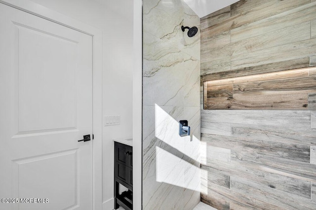 bathroom featuring tiled shower and vanity