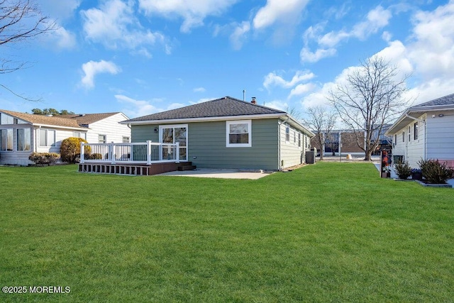 back of property with a yard and a wooden deck