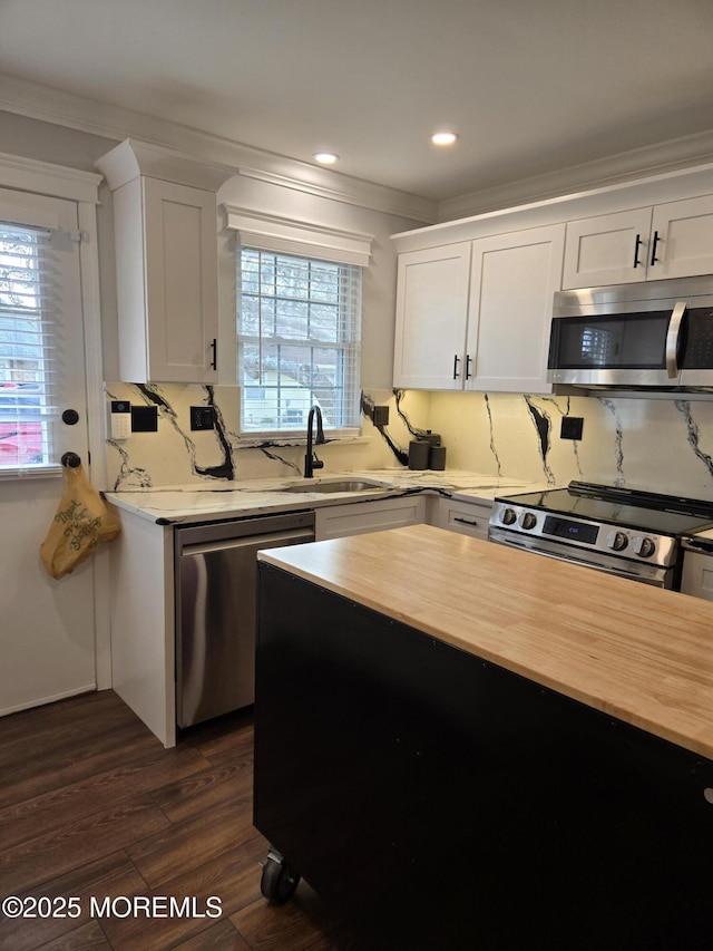 kitchen featuring sink, white cabinetry, crown molding, and appliances with stainless steel finishes