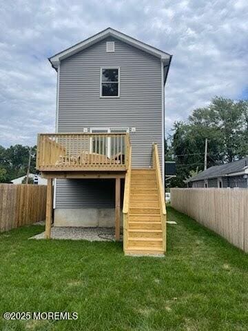 rear view of property with a wooden deck and a yard