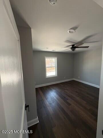 spare room with dark hardwood / wood-style floors and ceiling fan