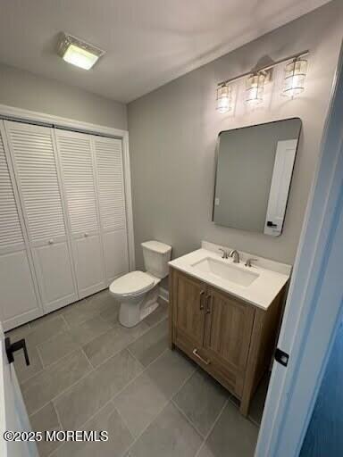 bathroom featuring vanity, tile patterned flooring, and toilet