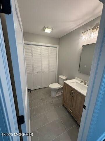 bathroom featuring vanity, tile patterned floors, and toilet