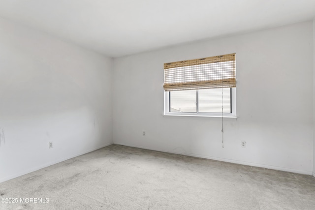 spare room featuring light colored carpet