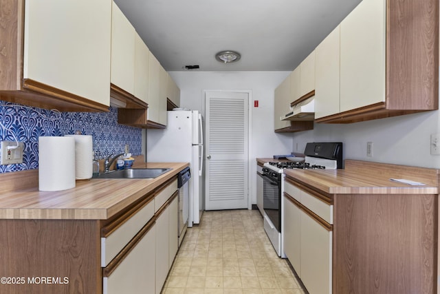 kitchen with gas range, stainless steel dishwasher, tasteful backsplash, white cabinets, and sink