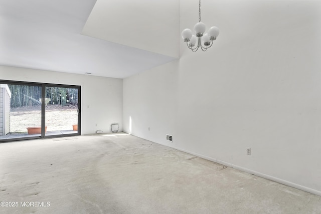 carpeted spare room with a notable chandelier