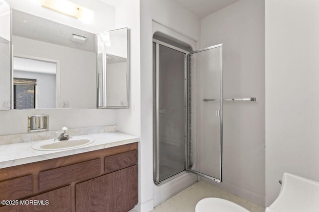 bathroom featuring a shower with door and vanity