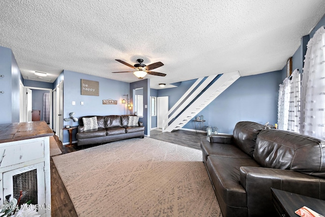 living room with a textured ceiling, ceiling fan, and dark hardwood / wood-style flooring