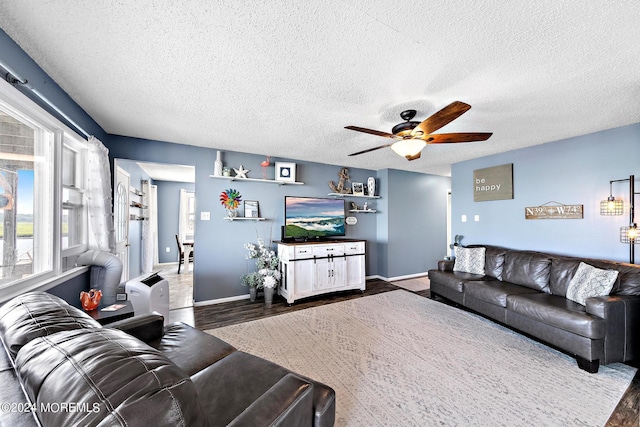 living room featuring a textured ceiling, ceiling fan, and dark hardwood / wood-style flooring