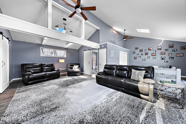 living room featuring ceiling fan, lofted ceiling with skylight, a barn door, and dark hardwood / wood-style floors