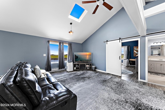 living room featuring high vaulted ceiling, ceiling fan, a barn door, and a skylight