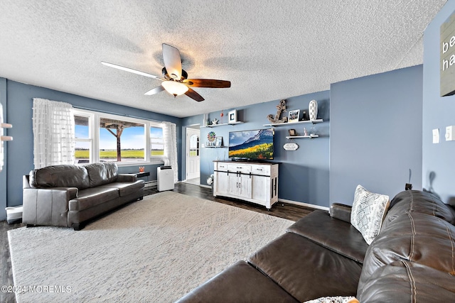 living room with a textured ceiling, ceiling fan, and dark wood-type flooring