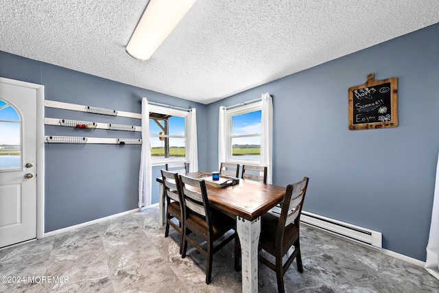 dining room with a baseboard heating unit, a textured ceiling, and a water view