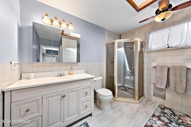 bathroom with tile walls, toilet, ceiling fan, and walk in shower