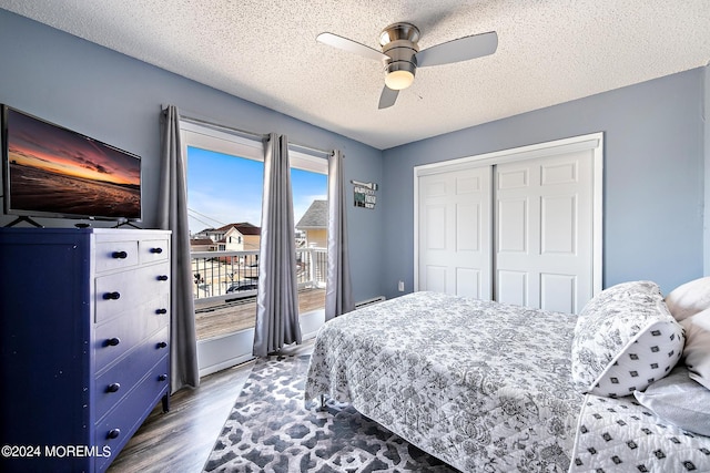 bedroom with ceiling fan, hardwood / wood-style floors, a closet, and a textured ceiling