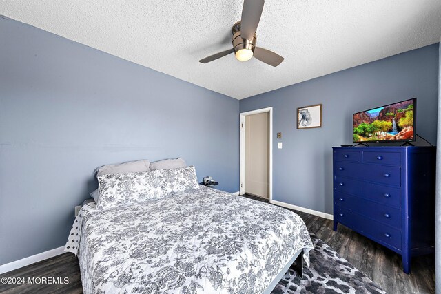 bedroom featuring dark hardwood / wood-style flooring, a textured ceiling, and ceiling fan