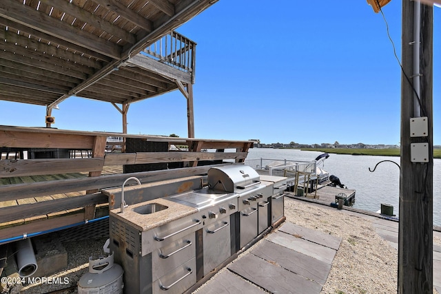 view of patio with sink, area for grilling, and a water view