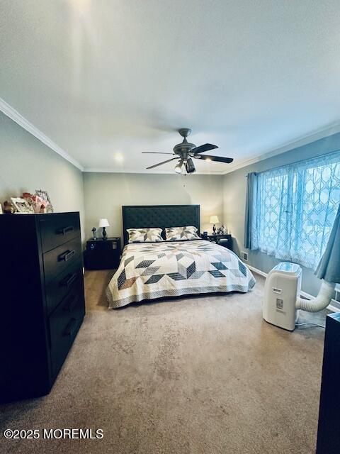 bedroom featuring ceiling fan, carpet, and crown molding