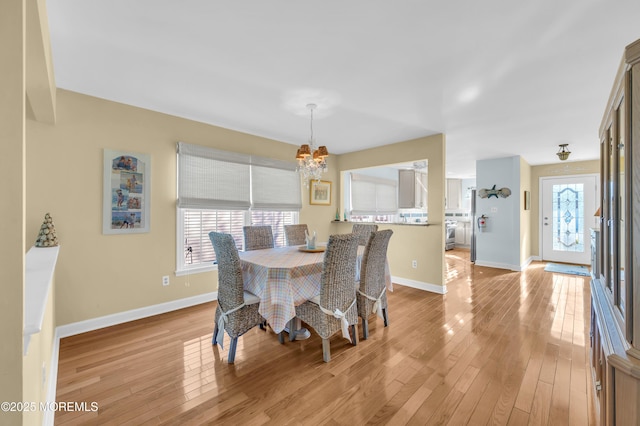 dining space featuring light hardwood / wood-style flooring and a chandelier