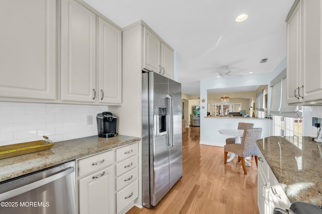 kitchen with ceiling fan, stainless steel appliances, white cabinetry, and light stone countertops