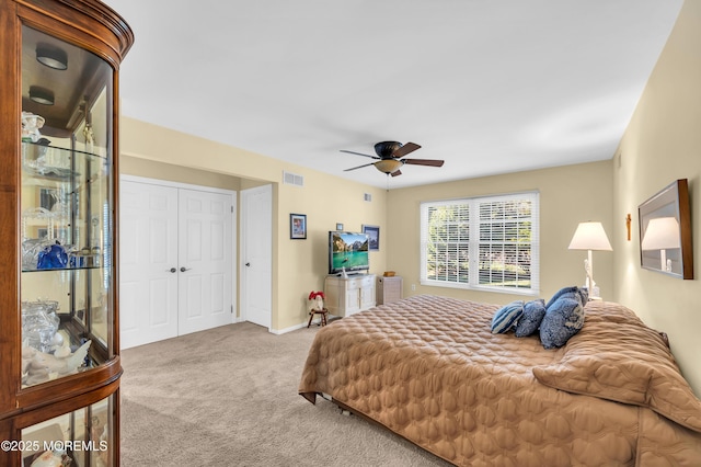 carpeted bedroom with ceiling fan and a closet