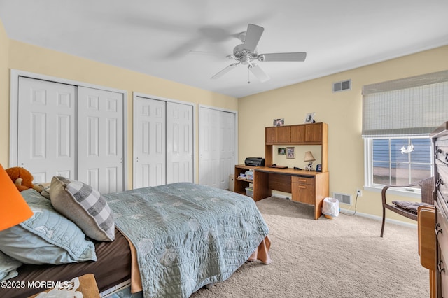 bedroom featuring two closets, ceiling fan, and light colored carpet