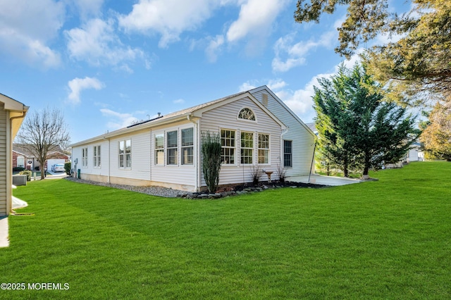 back of property with a yard and central AC unit