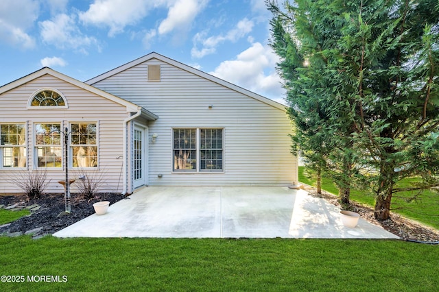 back of property featuring a lawn and a patio