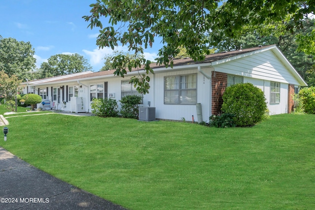 ranch-style house featuring central AC and a front yard