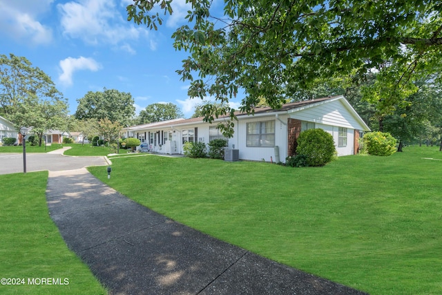 single story home with a front yard and cooling unit