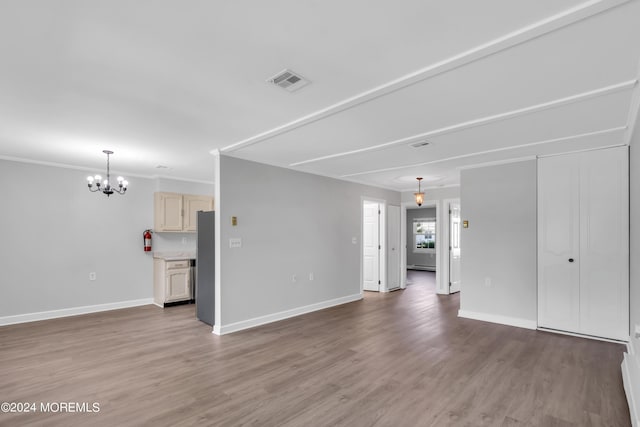 unfurnished living room featuring baseboard heating, crown molding, a chandelier, and hardwood / wood-style flooring