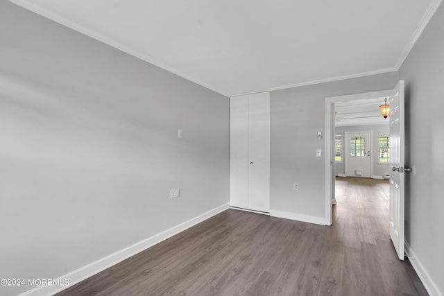 empty room with hardwood / wood-style flooring and crown molding