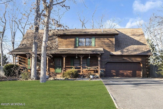 log cabin featuring covered porch, a front lawn, and a garage