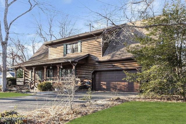 log-style house featuring a garage and a porch