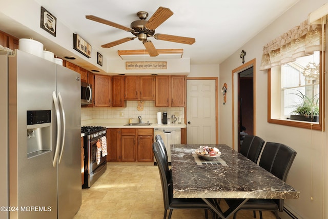 kitchen with stainless steel appliances, a breakfast bar, baseboard heating, backsplash, and ceiling fan