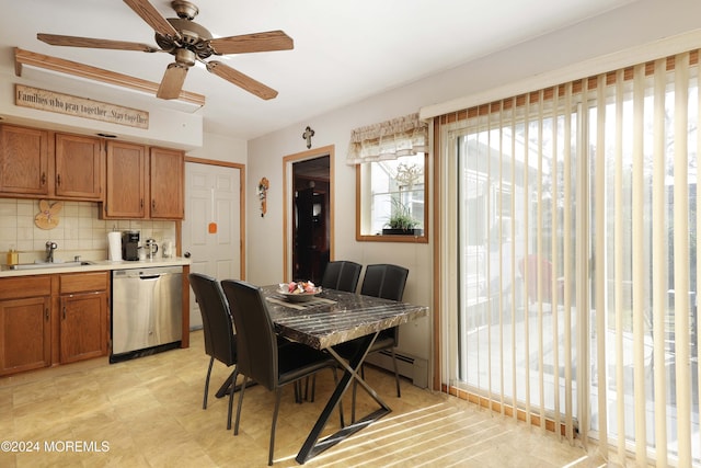 dining space with sink, ceiling fan, and baseboard heating