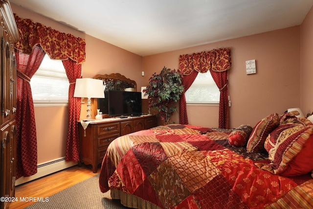 bedroom featuring baseboard heating and light hardwood / wood-style flooring