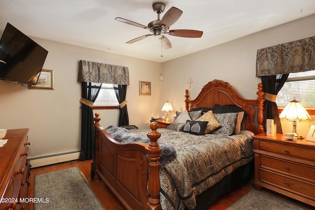 bedroom featuring a baseboard heating unit, ceiling fan, dark hardwood / wood-style floors, and multiple windows