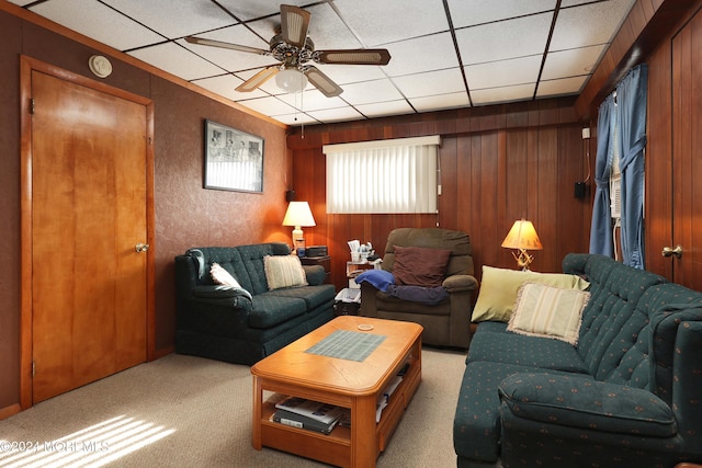 living room with light colored carpet, ceiling fan, and wooden walls