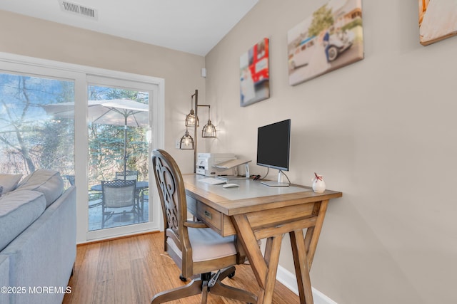 home office with light hardwood / wood-style floors