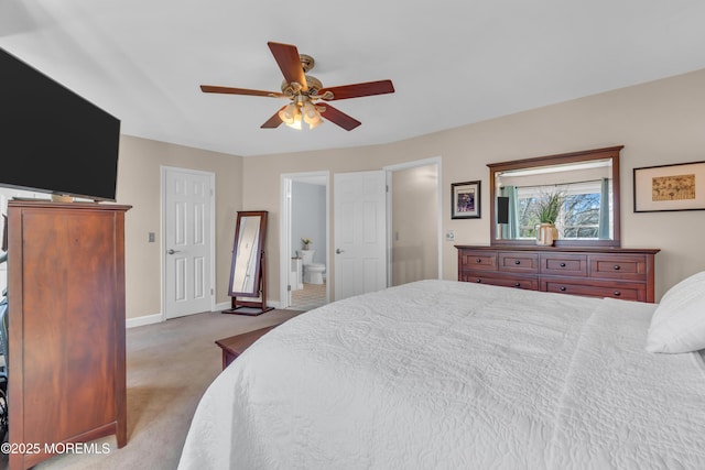 bedroom featuring ensuite bath, light colored carpet, and ceiling fan