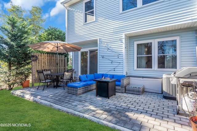 view of patio with an outdoor living space with a fire pit