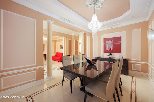 tiled dining area featuring a tray ceiling, an inviting chandelier, ornamental molding, and decorative columns