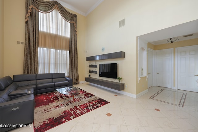 living room with light tile patterned floors, a towering ceiling, and crown molding