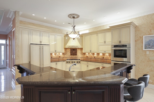 kitchen featuring decorative light fixtures, dark stone countertops, a kitchen breakfast bar, light tile patterned floors, and cream cabinetry