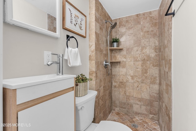 bathroom featuring toilet, vanity, and a tile shower