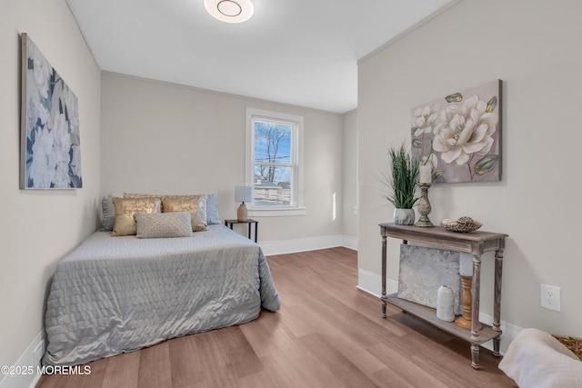 bedroom with ornamental molding and hardwood / wood-style flooring