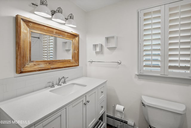 bathroom with a baseboard heating unit, vanity, and toilet