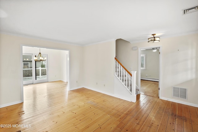 unfurnished room with a baseboard heating unit, ceiling fan with notable chandelier, ornamental molding, and light hardwood / wood-style floors