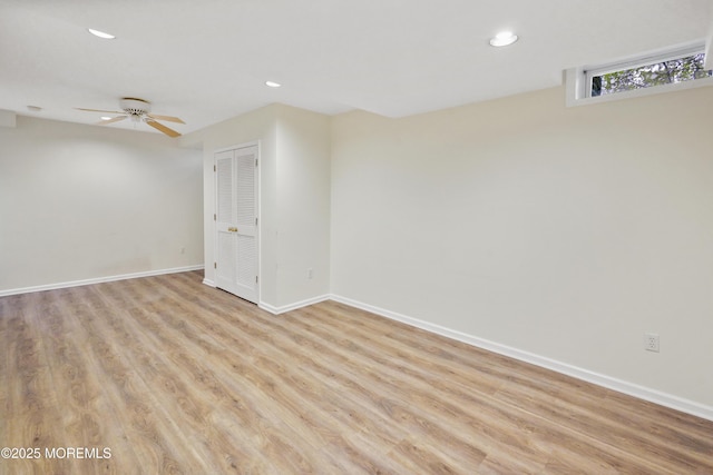 basement with ceiling fan and light hardwood / wood-style floors